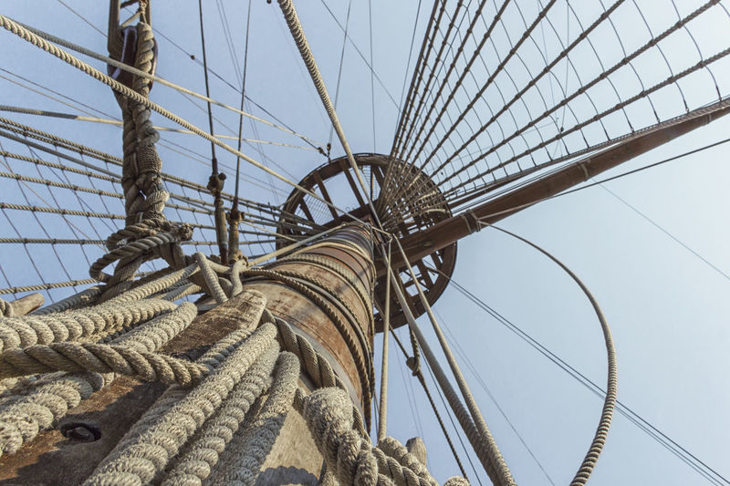 Suspension bridge on galleon with wood and rope against sky
