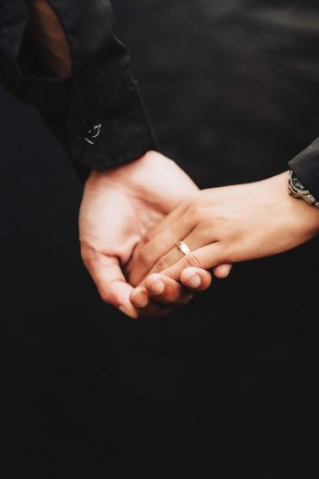 A man's hand holding his lover's hand