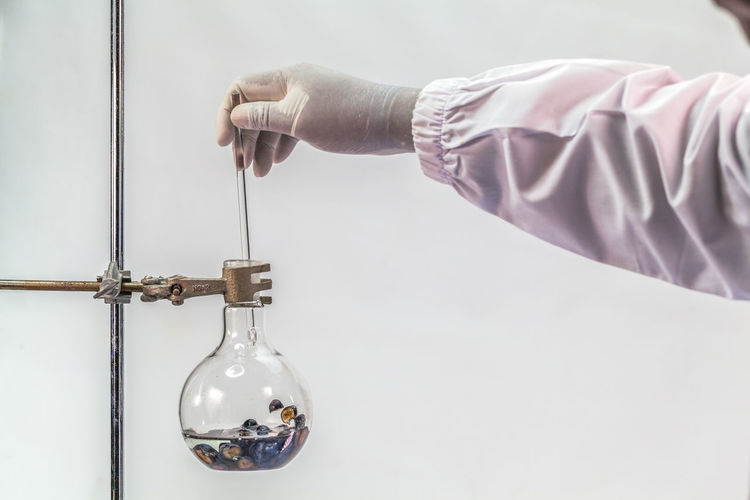 Cropped hand of scientist analyzing chemical in laboratory