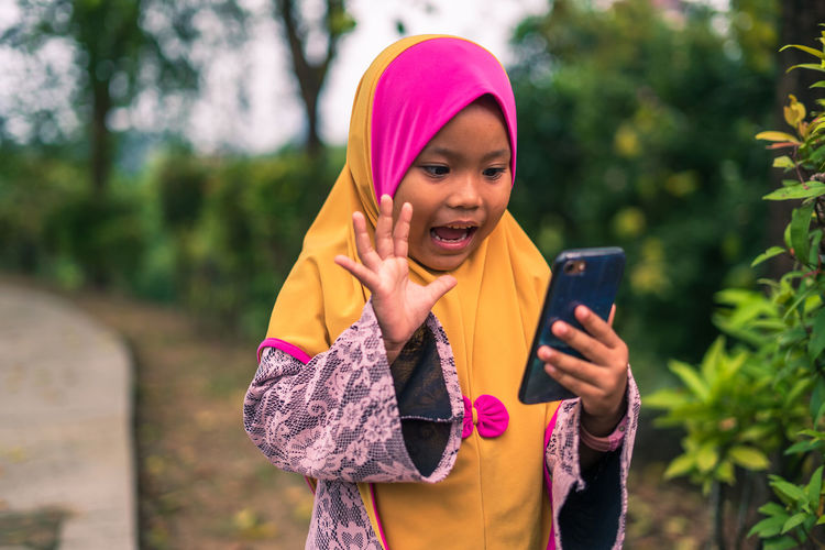 Young woman using mobile phone while standing outdoors