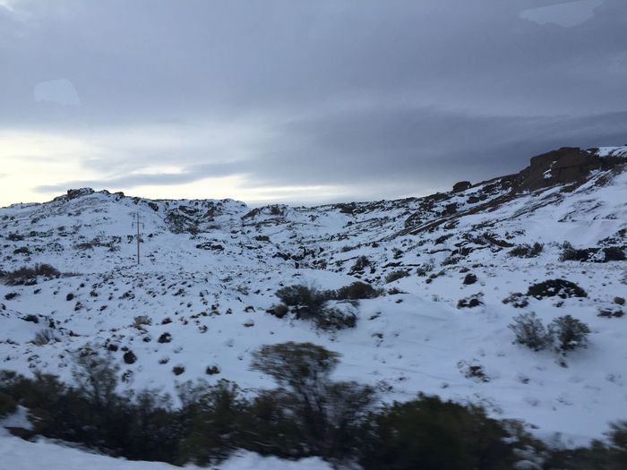 Scenic view of mountains against cloudy sky