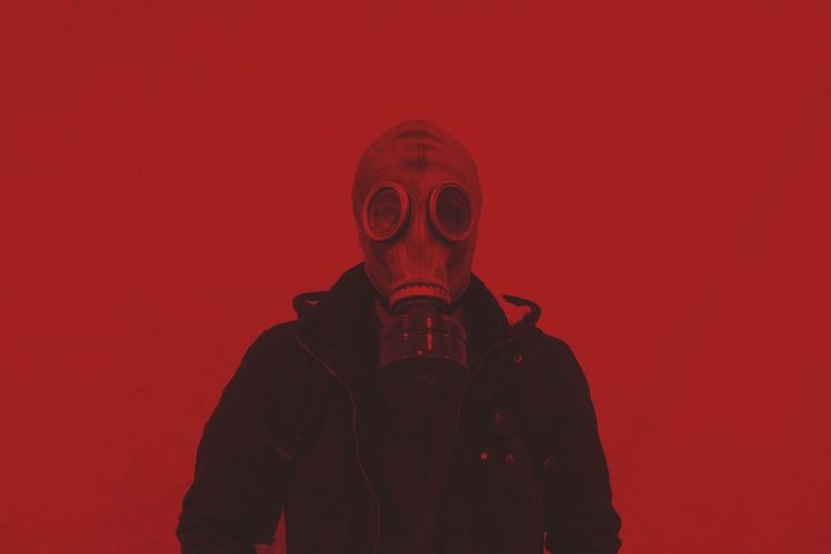 Man standing against red wall