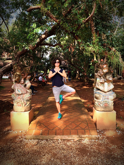 Full length of woman standing by tree against plants