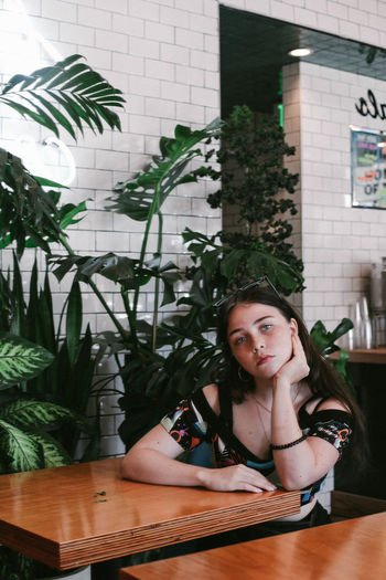 Portrait of woman sitting at table in home