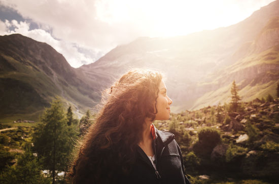 Young woman standing against mountains
