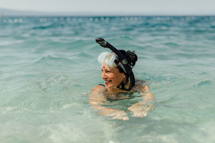 Smiling woman swimming in sea
