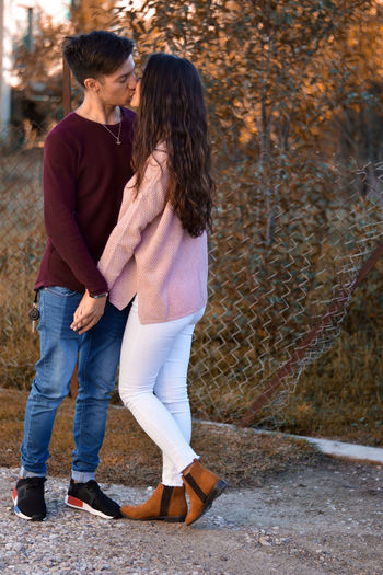 Full length of young couple kissing outdoors