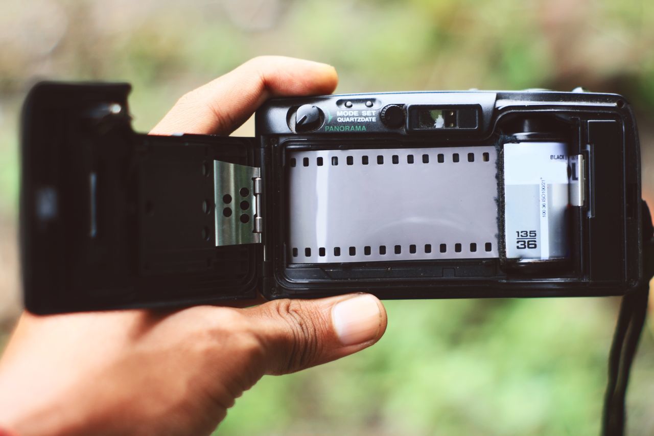 Cropped image of person holding old-fashioned camera