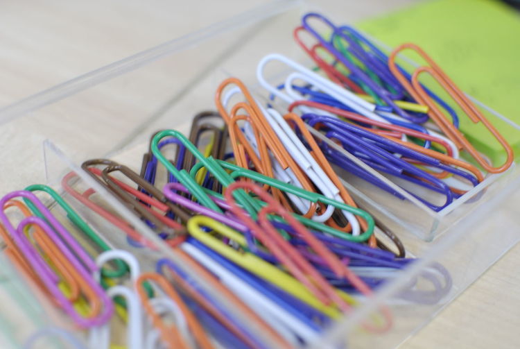 Close-up of colored paper clips on table