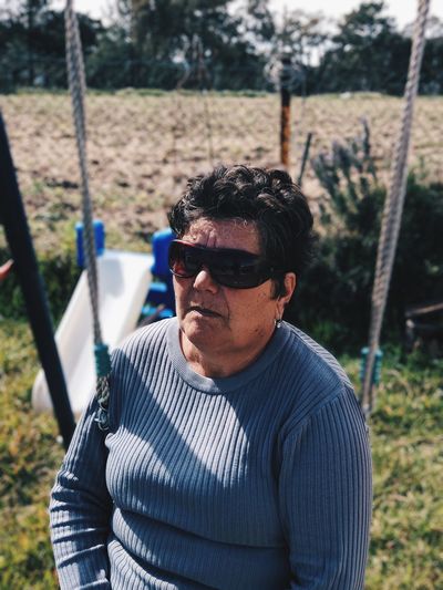 Woman wearing sunglasses while sitting on swing