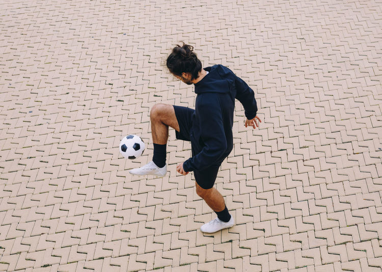Full length of man playing soccer ball