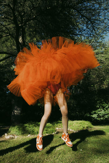Low section of woman standing on field