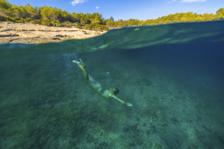 Girl diving in the adriatic sea on hvar island, croatia