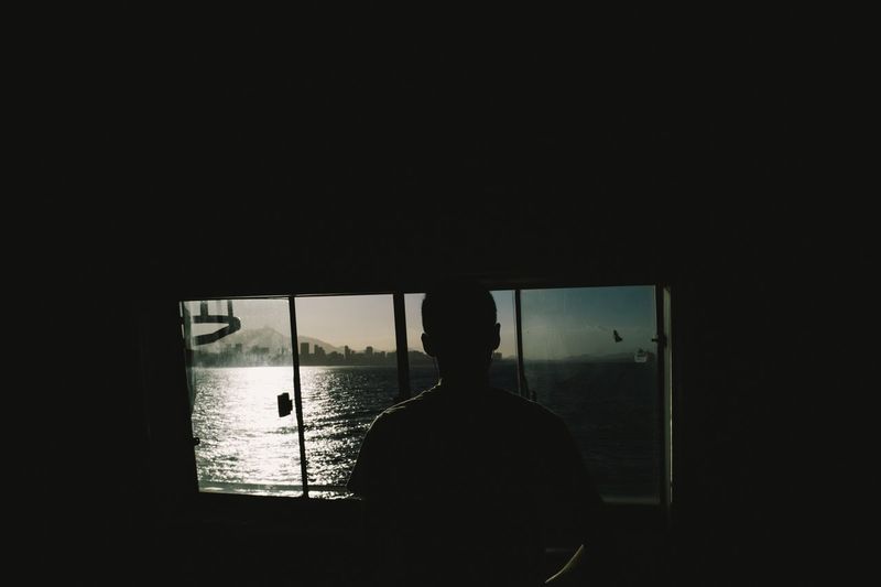 Silhouette man against window
