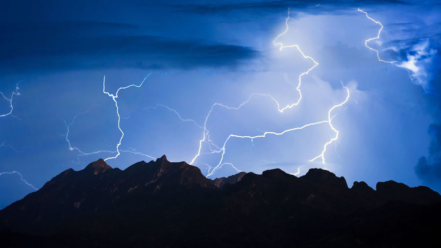 Low angle view of lightning over mountain