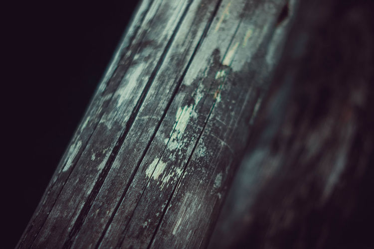 Close-up of wet wooden plank against black background