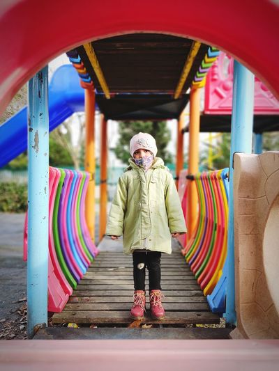 Portrait of girl standing on multi colored playground