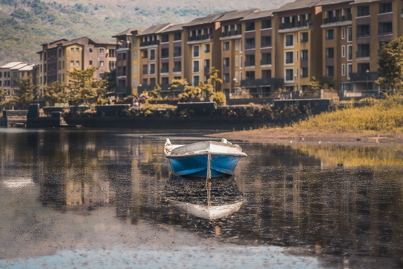 Boat on lake by buildings