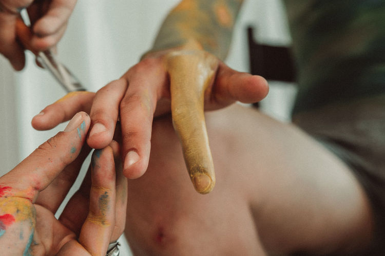 Cropped image of woman painting person hands