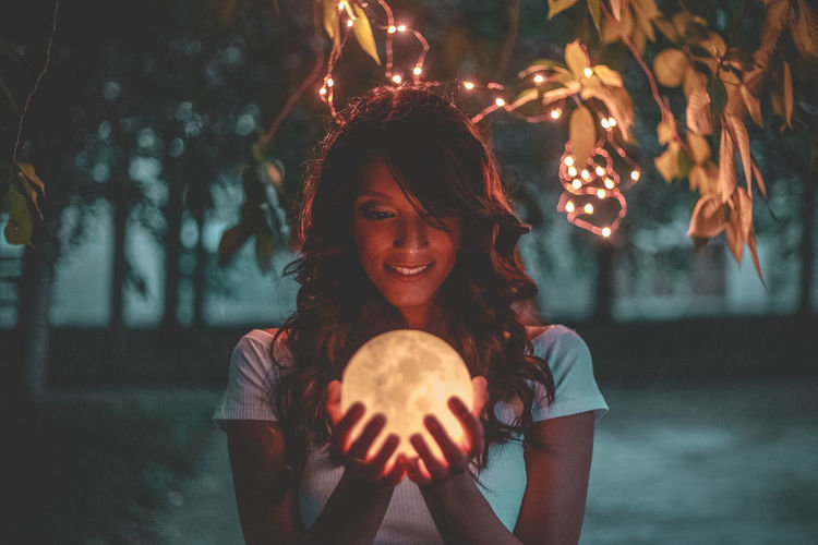Woman holding illuminated light painting at night