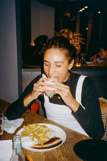 Midsection of woman eating food at restaurant