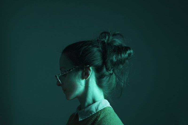 Close-up young woman against colored background