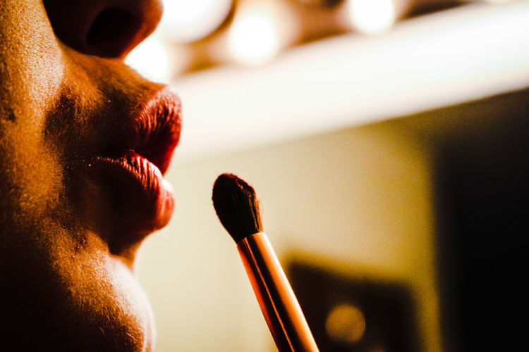 Cropped image of woman applying lipstick