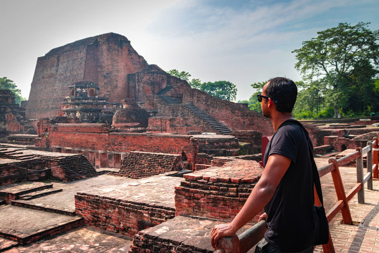 Man posing at red bricks background of nalanada ruins