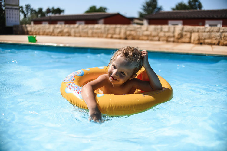 Little girl swimming in the pool in the rubber ring