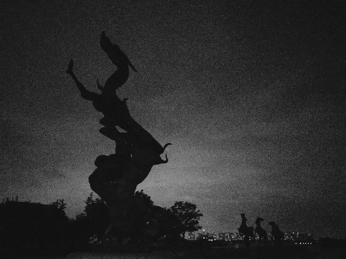Low angle view of silhouette statue against sky at dusk
