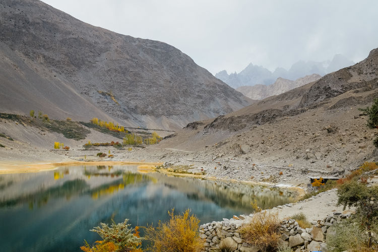 Reflection in water of borith lake against karakoram mountain rang. gilgit baltistan, pakistan.