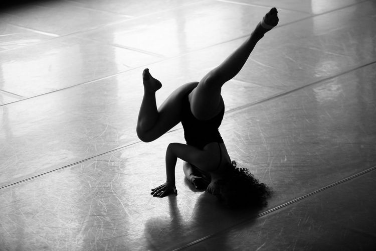 Full length of sensuous naked girl dancing on floor