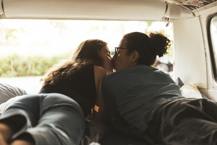 Young couple kissing each other in camping van