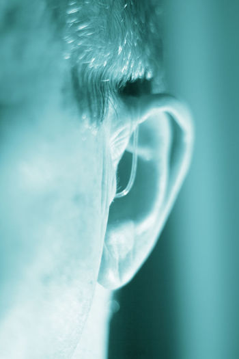 Close-up of man wearing hearing aid at home