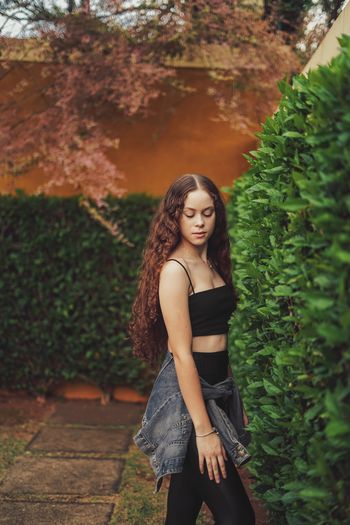 Teenage girl standing against plants