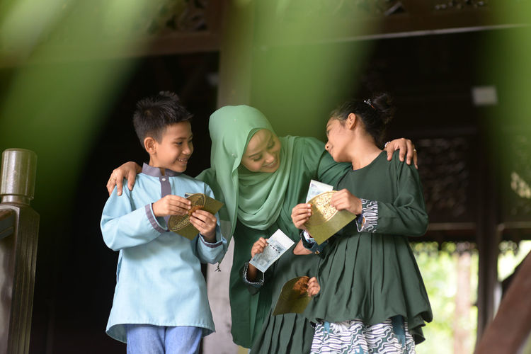 Mother with child holding envelop standing at home