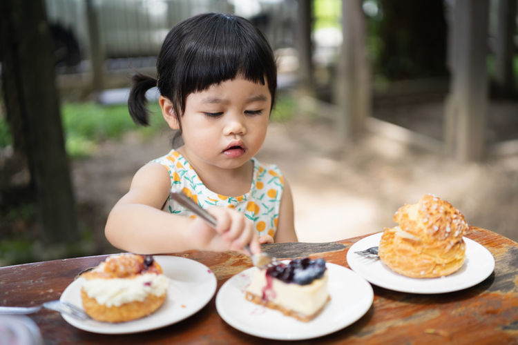Full length of cute baby girl in plate on table