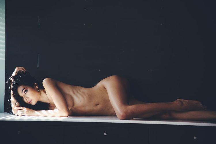 Portrait of seductive woman lying on floor