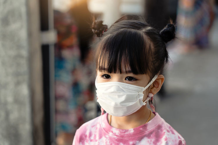 Close-up of girl wearing mask outdoors