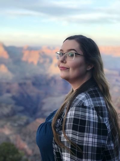 Portrait of young woman standing on mountain