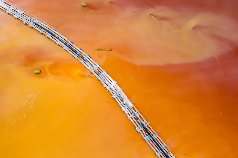 High angle view of cranes against orange sky