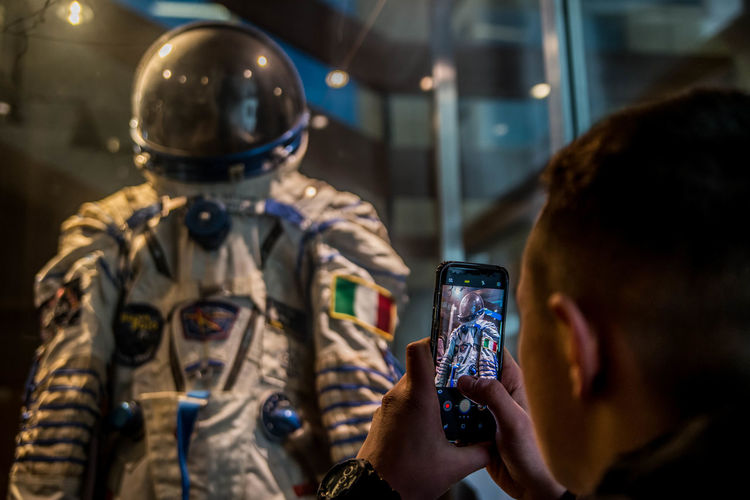 Man photographing space suit at museum
