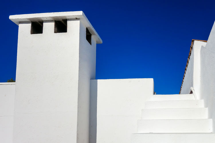 Low angle view of white building against blue sky
