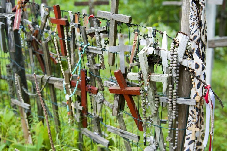 High angle view of wooden crosses attached to fence