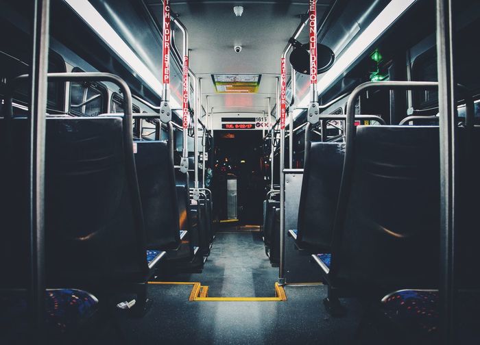 Interior of illuminated empty bus at night