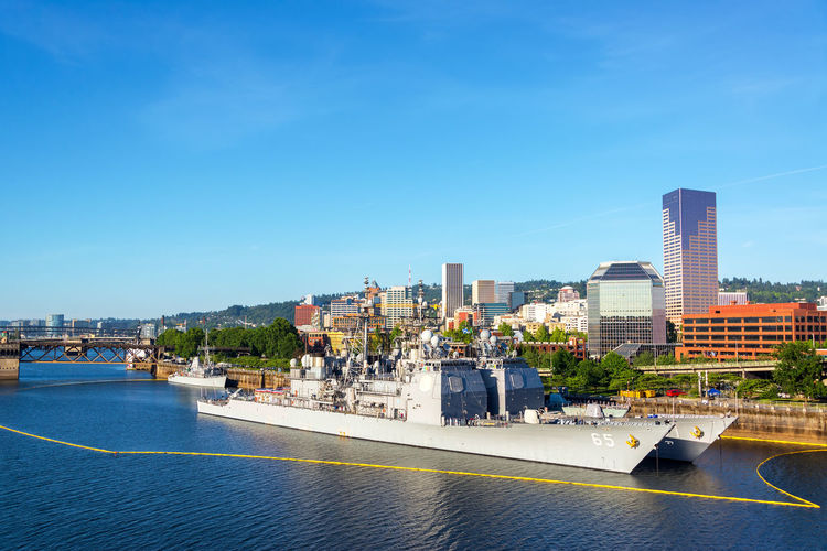 Navy battleship moored in willamette river at tom mccall waterfront park against sky