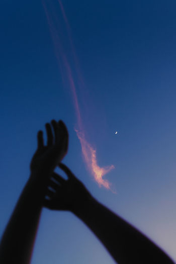 Silhouette of woman's hands at sunset with the moon