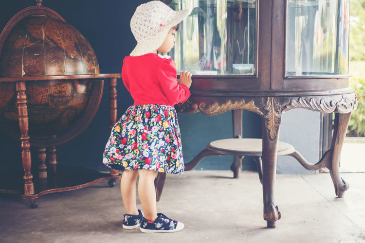 Rear view of girl standing against seat