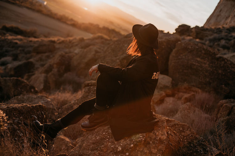 Rear view of woman standing on rock
