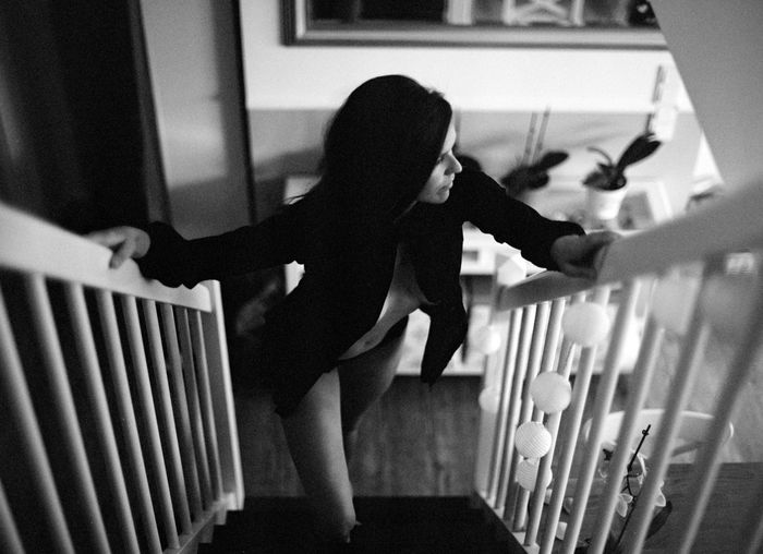 Rear view of woman standing on staircase at home